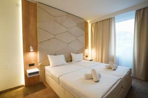 um quarto com uma cama grande com duas toalhas em Hotel Sumadija em Belgrado