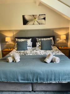 a bedroom with a large bed with two pillows at Rivendell Guest House in Keswick