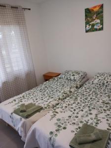Schlafzimmer mit einem Bett mit einer grünen und weißen Bettdecke in der Unterkunft Къща за гости АлеЯ in Kranewo