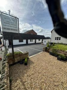 um sinal em frente a um edifício com estacionamento em Little Park Holiday Homes Self Catering Cottages 1 & 2 bedrooms available close to Tutbury Castle em Tutbury