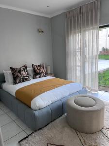 a bedroom with a large bed with a large window at Lanina Self Catering Apartments in Johannesburg