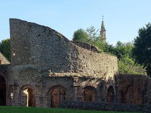 an old stone building with a tower in the background at les gites pléhedelais (TER) in Pléhédel