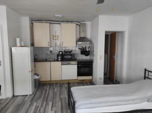 una cocina con armarios blancos y una cama en una habitación en Ferienwohnung im Zentrum von Oberhausen inklusive WLAN, en Oberhausen