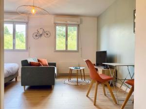 ein Wohnzimmer mit einem Sofa und einem Stuhl in der Unterkunft Appartement proche Centre-ville in Saint Lo