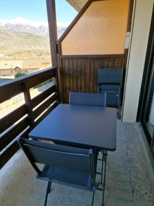 una mesa y sillas sentadas en un balcón en Appartement coquet situé au Plan d eau, en Embrun