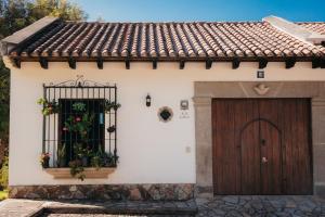 une maison blanche avec une porte et une fenêtre dans l'établissement Autumn in Antigua Boutique Hotel, à Antigua Guatemala