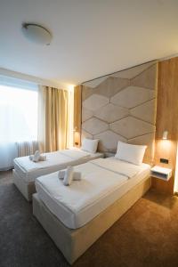 Un pat sau paturi într-o cameră la Hotel Sumadija