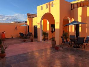 un patio al aire libre con mesas, sillas y sombrillas en Tres Iguanas Apart Hotel - New, cozy & spacious flats, short walk to beach en Loreto