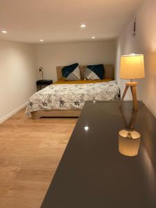 um quarto com uma cama e uma mesa com um candeeiro em Loft avec vue sur les voiliers em Martigues
