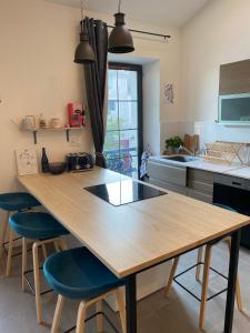 uma cozinha com uma mesa de madeira e cadeiras azuis em Loft avec vue sur les voiliers em Martigues