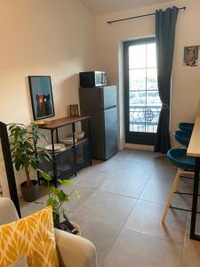 a living room with a refrigerator and a window at Loft avec vue sur les voiliers in Martigues