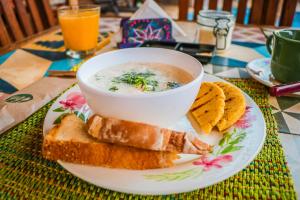 a bowl of soup on a plate with bread and crackers at Hotel Casa El Mandarino in Barichara