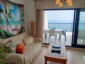 sala de estar con sofá y mesa en Ada Calypso Apartamento, frente al mar y castillo, Parking, Aire acondicionado, WiFi, Piscina, en Peñíscola