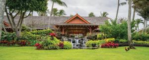 a house with a waterfall in a garden at Kauai Coast Resort at the Beach Boy in Kapaa
