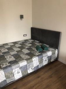 1 dormitorio con 1 cama con colcha a cuadros en Pilėnų apartamentai, en Panevėžys