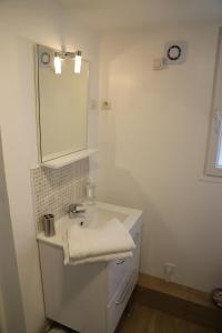 a white bathroom with a sink and a mirror at Le Fort Vauban in Ambleteuse +25 photos