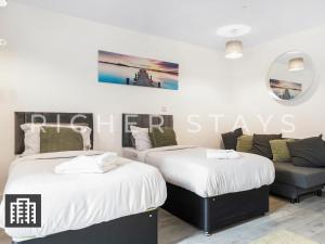 2 Betten in einem Zimmer mit Sofa in der Unterkunft Cosy Studio Apartment- Hemel Hempstead High Street in Hemel Hempstead