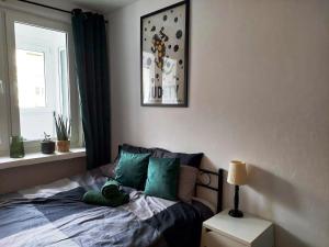 a bedroom with a bed with green pillows and a window at Salamandra - SUDETY in Głuszyca