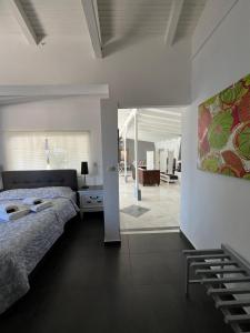 Luxury Loft in Porto Heli !!! في بورتوخيلي: غرفة نوم مع سرير وغرفة معيشة