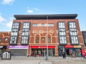 un edificio di mattoni rossi con un cartello sopra di Cosy Studio Apartment- Hemel Hempstead High Street a Hemel Hempstead