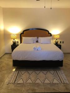a bedroom with a large bed with two towels on it at Tres Iguanas Apart Hotel - New, cozy & spacious flats, short walk to beach in Loreto