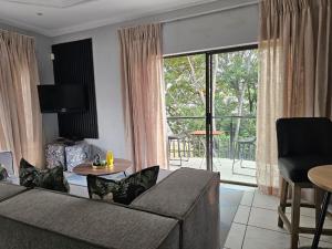 a living room with a couch and a large window at Lanina Self Catering Apartments in Johannesburg