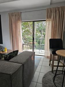 a living room with a couch and a table at Lanina Self Catering Apartments in Johannesburg