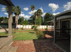 ein Haus mit einer Terrasse mit Palmen im Hintergrund in der Unterkunft BelaBela Guesthouse in Bela-Bela