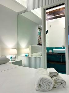 1 dormitorio con cama con espejo y lavamanos en Vinny's Relais - Deluxe rooms & Suite en Vietri