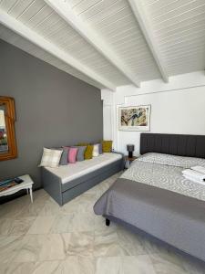 Luxury Loft in Porto Heli !!! في بورتوخيلي: غرفة نوم بسريرين واريكة