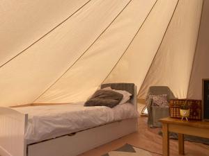 a bedroom with a bed in a tent at Trevena Cross Glamping in Helston