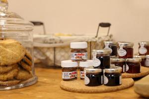 un grupo de tarros de mermelada en una mesa con galletas en Room & Breakfast Civico 07, en Fontanellato