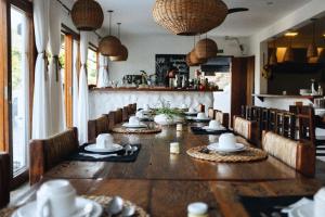 uma sala de jantar com uma mesa longa e cadeiras em Nai em Praia de Santiago