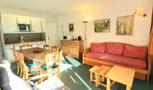 LE MUSTAG - Appartement MUSTAG 26 pour 6 Personnes 55 في لا بلاني: غرفة معيشة مع أريكة حمراء وطاولة