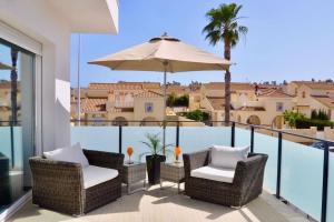 eine Terrasse mit 2 Stühlen und einem Sonnenschirm auf dem Balkon in der Unterkunft Casa Bella ~ Luxurious Villa in Alicante in Gran Alacant