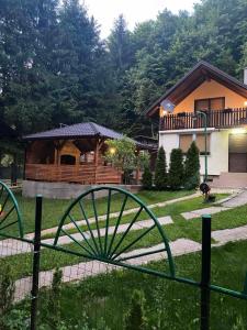 ein Haus mit einem Hund im Garten mit einem Zaun in der Unterkunft Forest House Bosnia in Busovača