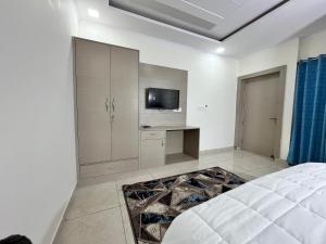 1 dormitorio con 1 cama y TV. en Cosy stay en Haldwāni