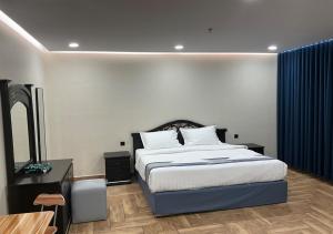 a bedroom with a bed and a television in it at Al Baida Suites Al Salam Branch in Al Madinah