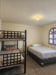 Blue Moon Hostel في أنتيغوا غواتيمالا: غرفة نوم بسريرين بطابقين ونافذة