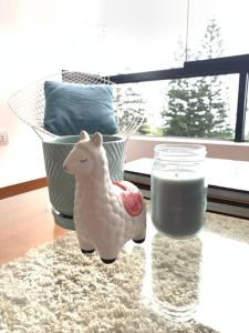 una statuina di una pecora accanto a un bicchiere di latte di Apartamento frente al mar a Lima