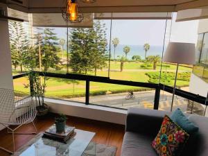 un soggiorno con una grande finestra e un divano di Apartamento frente al mar a Lima