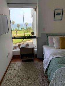 een slaapkamer met een bed en een raam met uitzicht bij Apartamento frente al mar in Lima