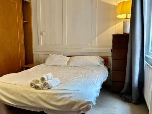 a bed with two towels and a lamp on it at Stay in Bloomsbury2 in London