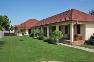 a house with a green lawn in front of it at Néró Apartman in Veľký Meder