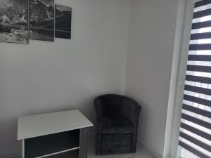 krzesło siedzące obok białego biurka w pokoju w obiekcie Apartament na Górnej 22 z parkingiem podziemnym w Kielcach