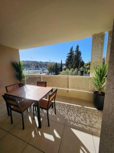 een tafel en stoelen op een balkon met uitzicht bij Joli appartement résidence neuve in Saint-Mandrier-sur-Mer
