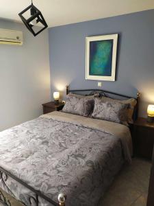 1 dormitorio con 1 cama con pared azul en Silkes Apartment en Sitia