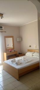a bedroom with a large bed and a mirror at Helena Inn in Svoronata