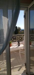 an open door to a patio with a table on the balcony at Helena Inn in Svoronata