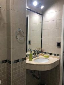 a bathroom with a sink and a mirror at Hostal del Sol - Fisherton in Rosario